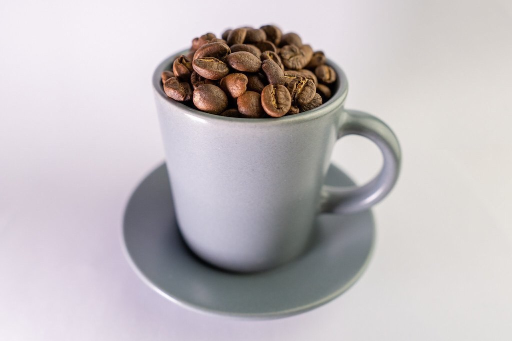 Cup filled with roasted coffee beans